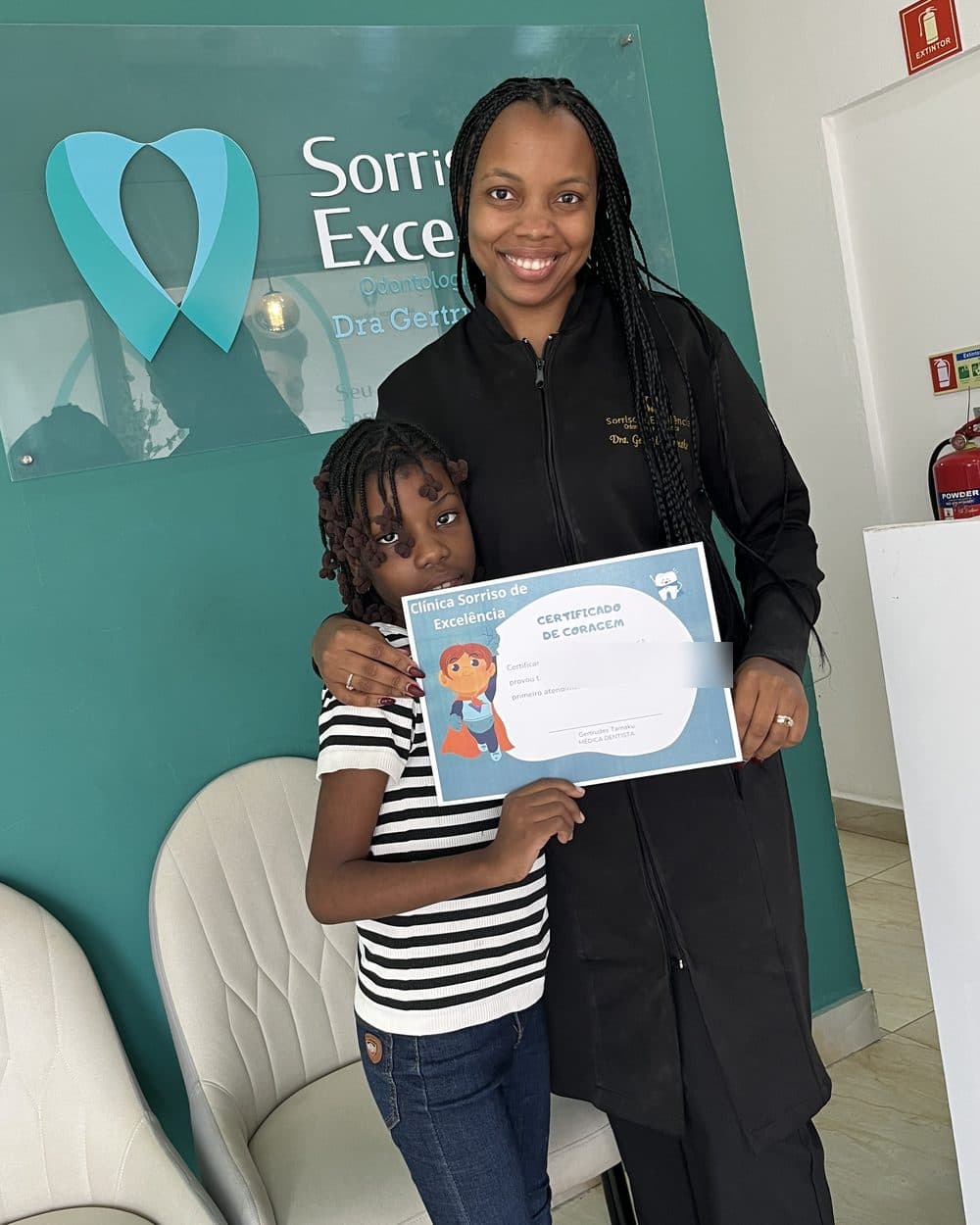 Dra. Gertrudes com uma pequena paciente e o Certificado de Coragem